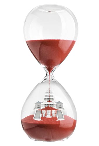 An hourglass with sand falling to the bottom, pilling on top of a Capital building.