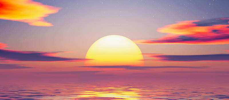 Vibrant ocean sunset with glowing sun, colorful pink and orange clouds, and reflections on calm water.